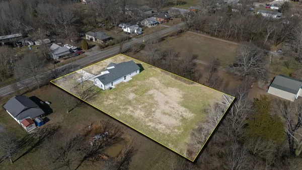 a view of a house with a backyard and a tree