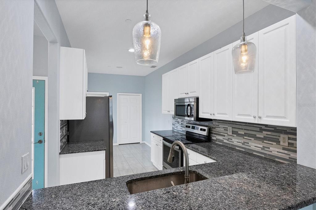 640 Back 9 Drive Venice, FL 34285 - Photo 26 of 54 a kitchen with stainless steel appliances granite countertop a refrigerator and a stove top oven