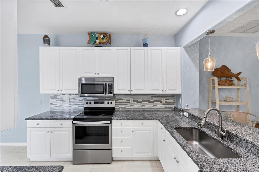 640 Back 9 Drive Venice, FL 34285 - Photo 30 of 54 a kitchen with granite countertop a sink stainless steel appliances and cabinets