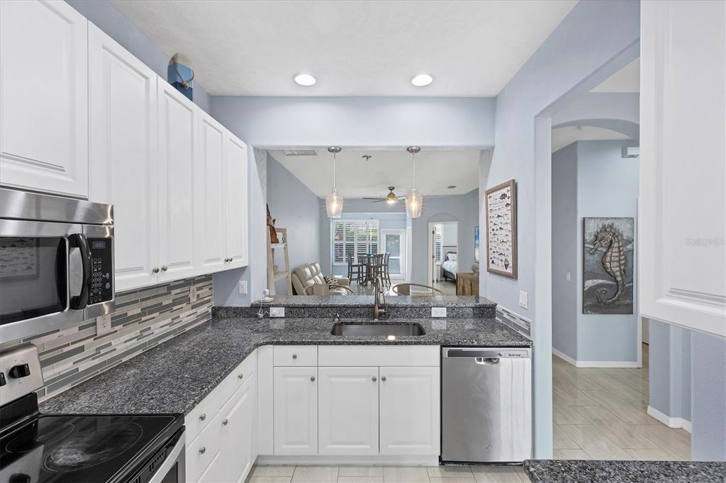 640 Back 9 Drive Venice, FL 34285 - Photo 36 of 54 a kitchen with stainless steel appliances granite countertop a sink stove and cabinets