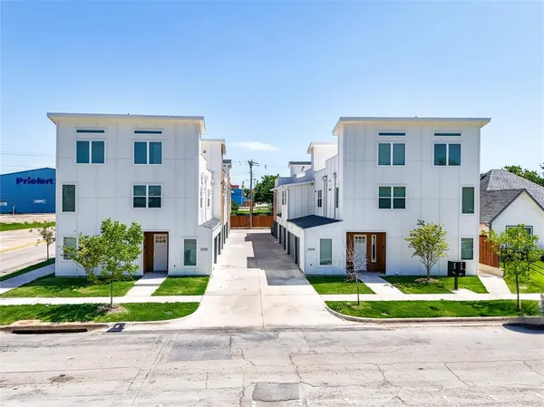 a front view of a house with a yard and potted plants