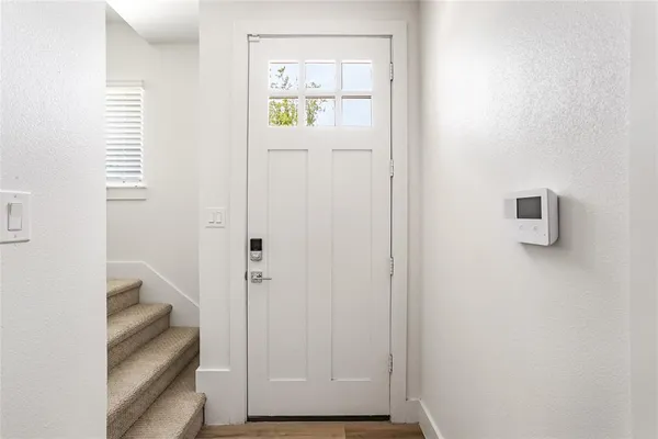an empty room with wooden floor closet and windows