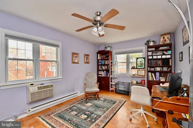 a living room with furniture a bookshelf and a window