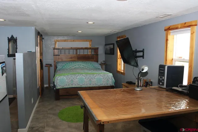 a room with pool table and two flat screen tv