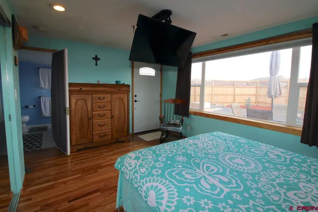 a bedroom with a bed and a large window