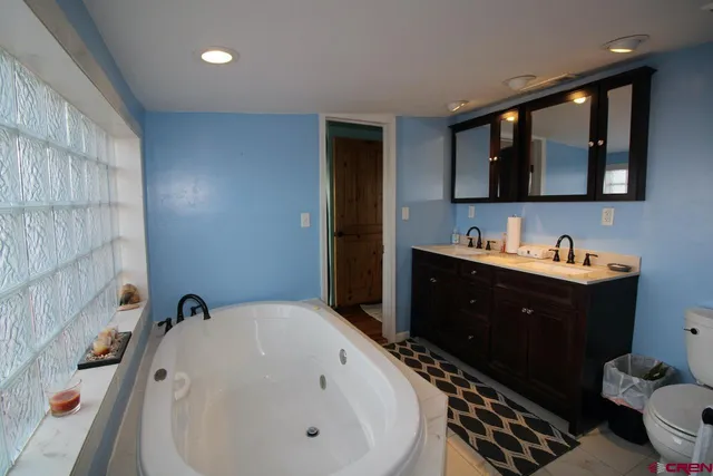 a bathroom with a tub sink and mirror
