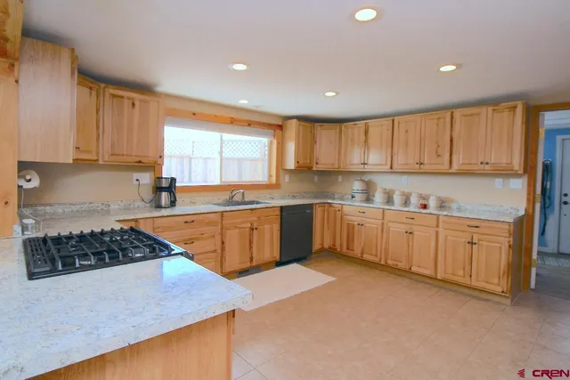 a kitchen with stainless steel appliances granite countertop a stove sink and cabinets