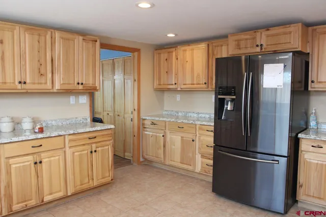 a kitchen with stainless steel appliances granite countertop a refrigerator a stove a sink and cabinets