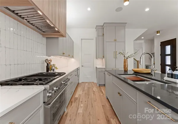 a kitchen with kitchen island stainless steel appliances a sink stove and cabinets