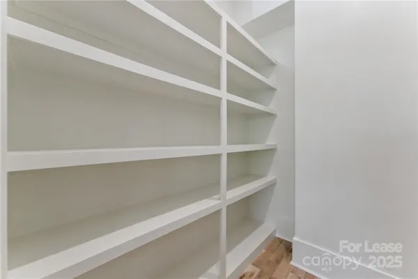 a view of walk in closet with empty racks