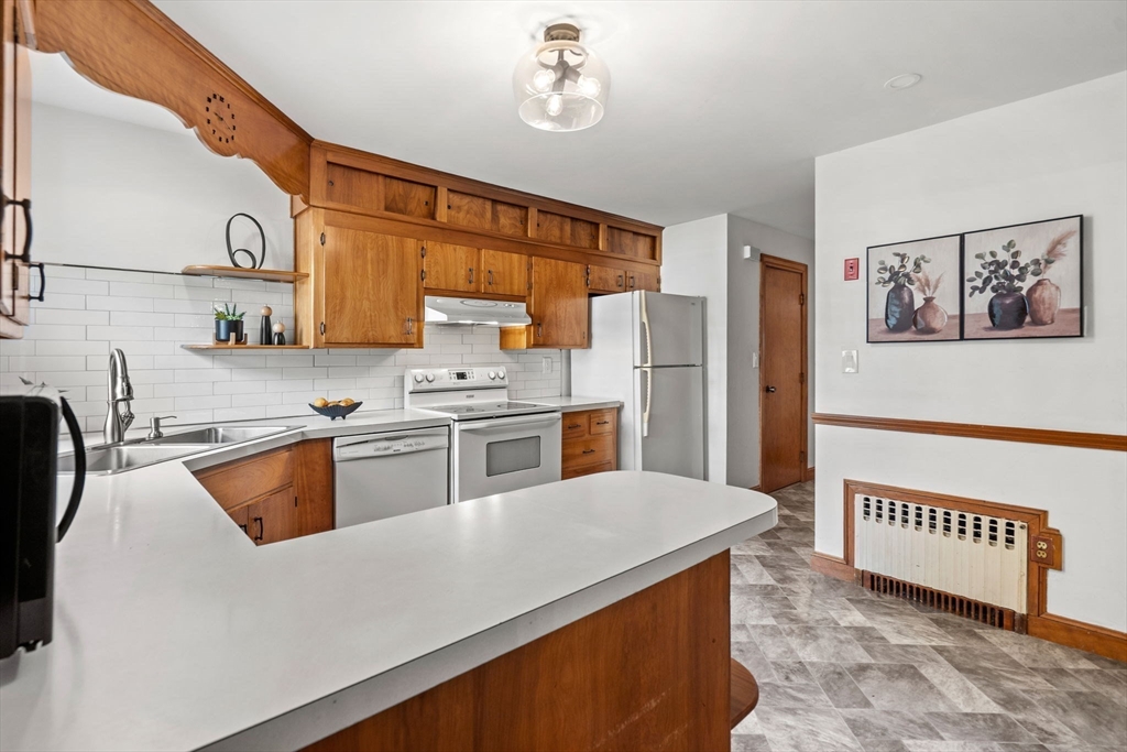 58 Spring Street Wakefield, MA 01880 - Photo 11 of 41 a kitchen with stainless steel appliances granite countertop a sink a stove a refrigerator a washer and dryer