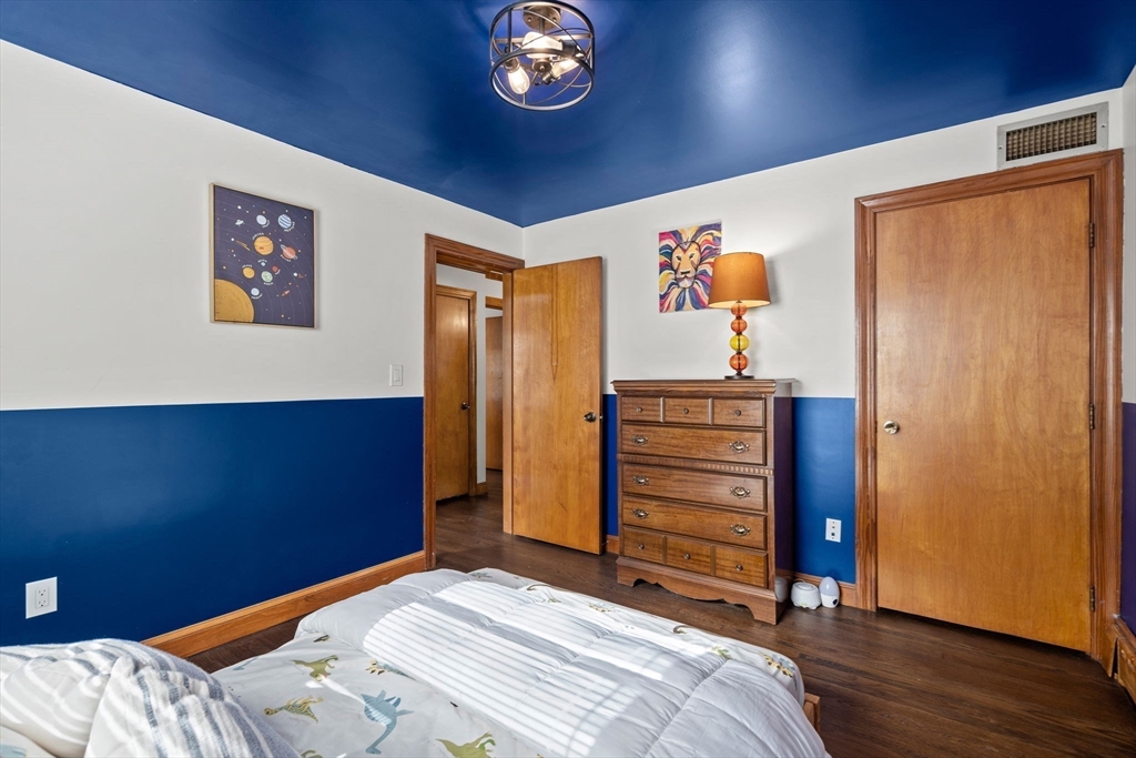 58 Spring Street Wakefield, MA 01880 - Photo 22 of 41 a bedroom with a bed and a chandelier