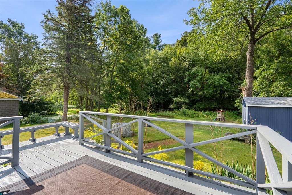 58 Spring Street Wakefield, MA 01880 - Photo 38 of 41 a view of a tennis ground with a large pool and lawn chairs under an umbrella
