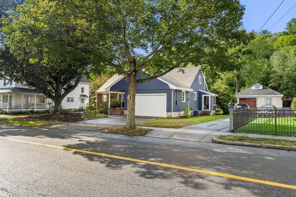 58 Spring Street Wakefield, MA 01880 - Photo 39 of 41 a front view of a house with a yard and large trees