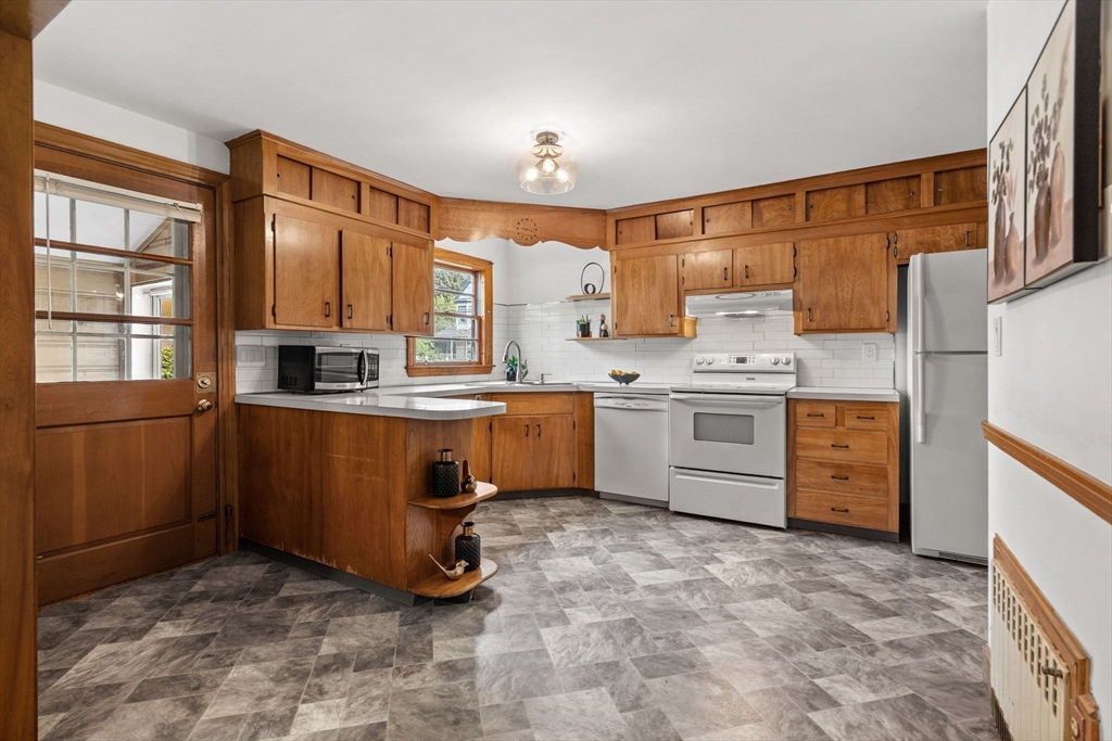 58 Spring Street Wakefield, MA 01880 - Photo 8 of 41 a room with kitchen island a sink a stove and cabinets