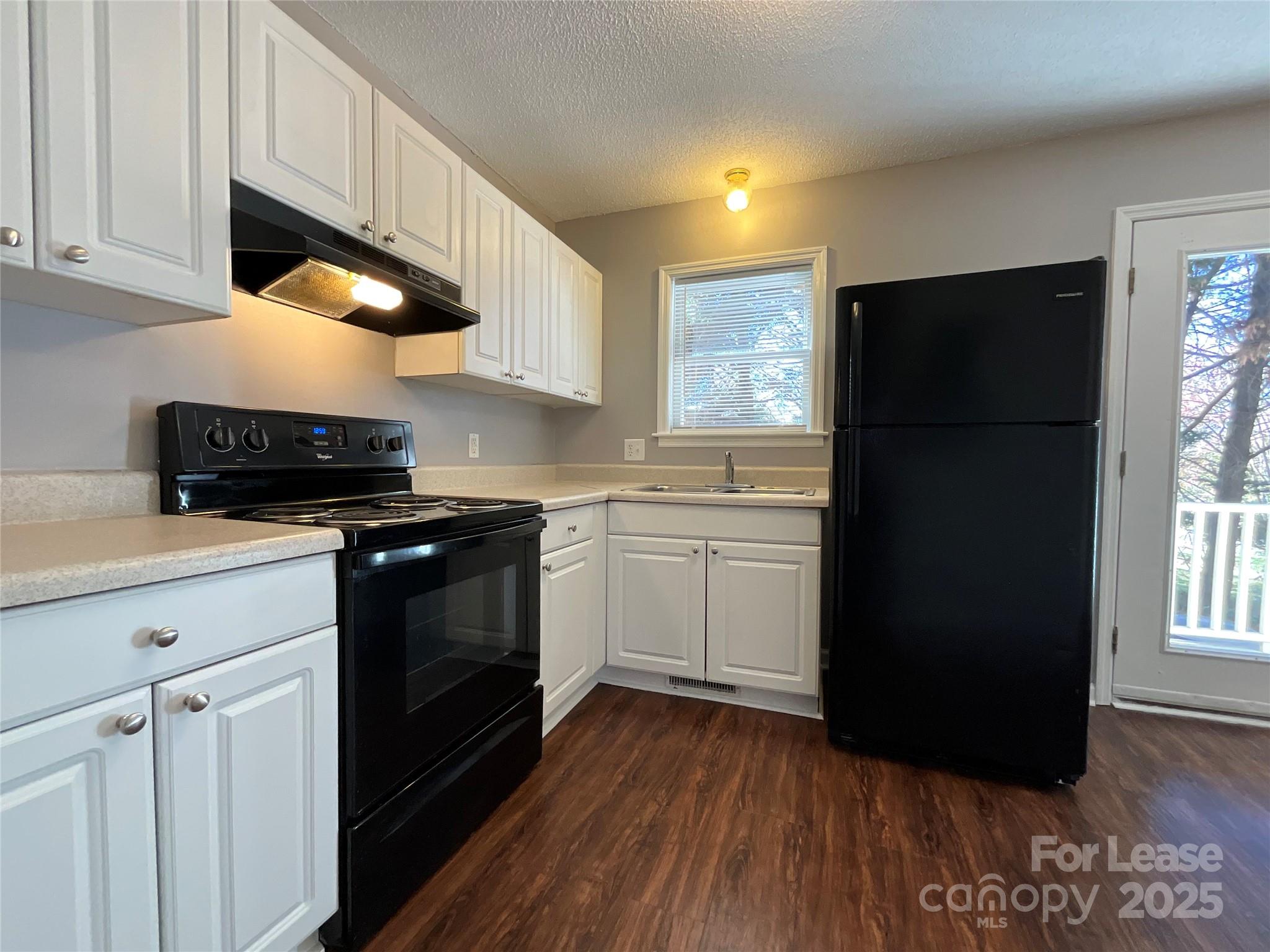 206 West 15th Street, Unit 2 Newton, NC 28658 - Photo 5 of 14 a kitchen with a sink a refrigerator and window