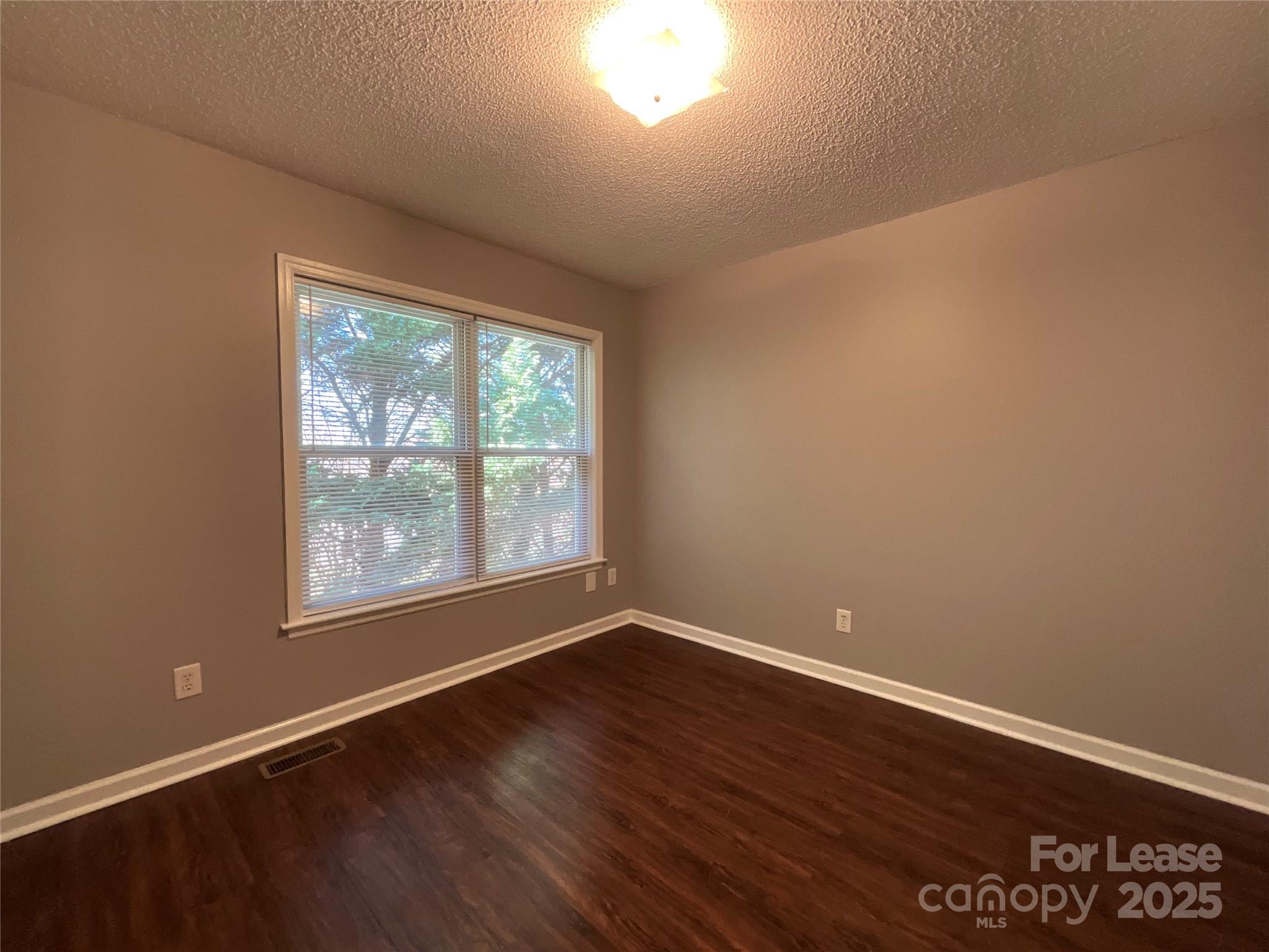 206 West 15th Street, Unit 2 Newton, NC 28658 - Photo 9 of 14 an empty room with wooden floor and windows