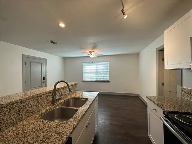 a kitchen with granite countertop a sink and a stove