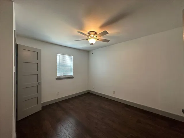 an empty room with a window and a ceiling fan