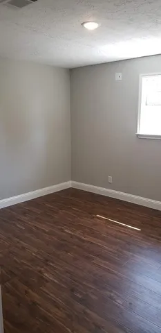 a view of a room with wooden floor and window