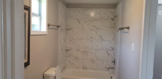 a bathroom with a bathtub and shower