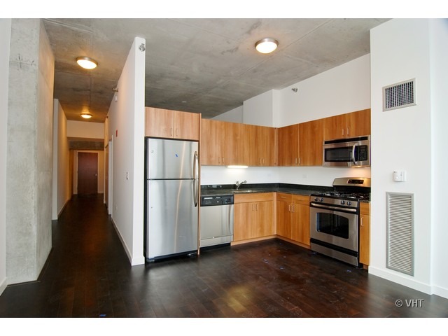 235 West Van Buren Street, Unit 3520 Chicago, IL 60607 - Photo 4 of 17 a kitchen with stainless steel appliances granite countertop a refrigerator a sink a stove and oven with wooden floor
