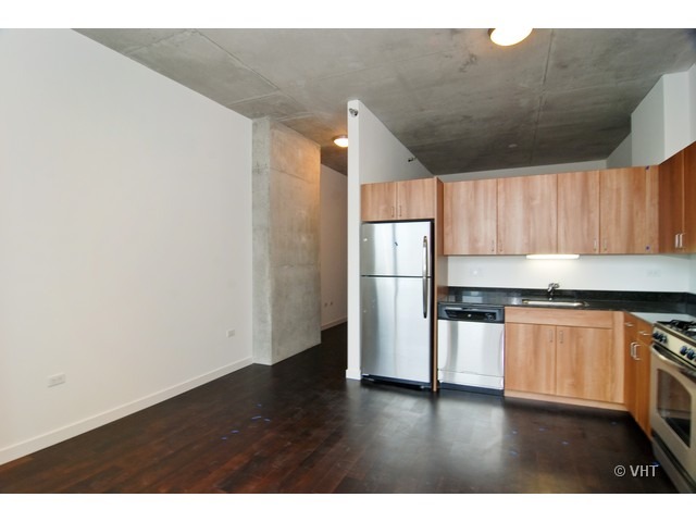 235 West Van Buren Street, Unit 3520 Chicago, IL 60607 - Photo 5 of 17 a kitchen with granite countertop a refrigerator and a stove top oven