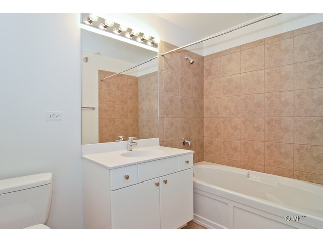 235 West Van Buren Street, Unit 3520 Chicago, IL 60607 - Photo 7 of 17 a bathroom with a sink mirror vanity and toilet