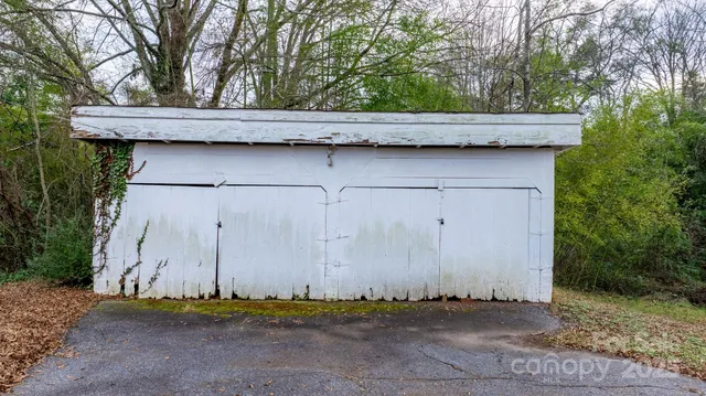an aerial view of a house with a yard and a large tree