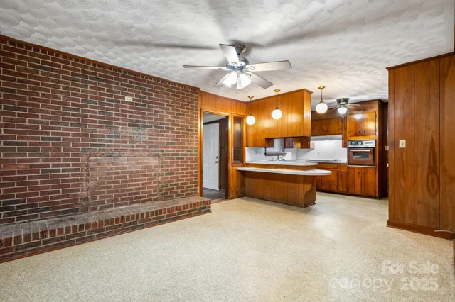 an empty room with wooden floor and windows with curtains