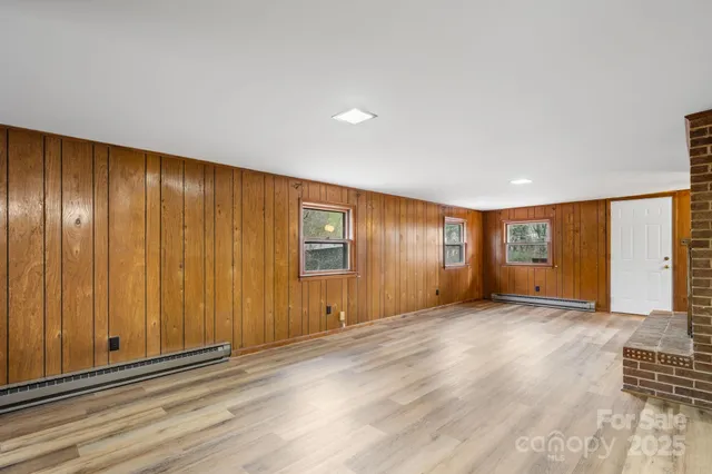 a view of an empty room with a fireplace and a window