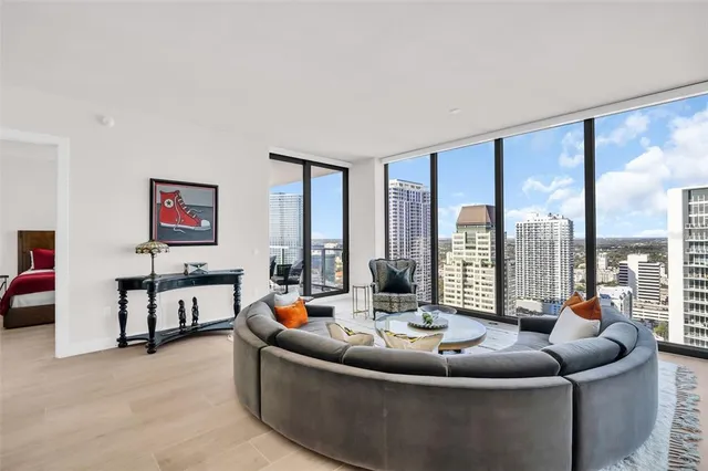 a living room with furniture and a floor to ceiling window