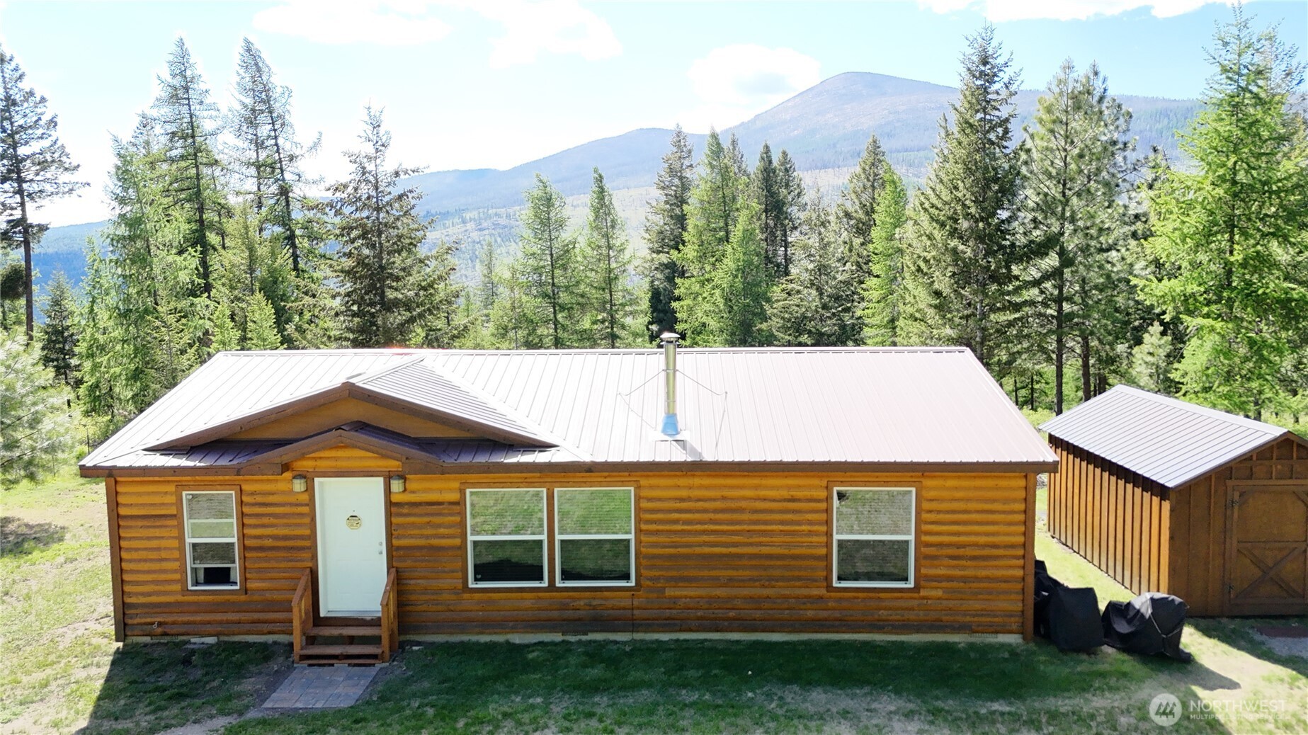393 Summer Road Tonasket, WA 98855 - Photo 1 of 37 a view of a white house next to a yard