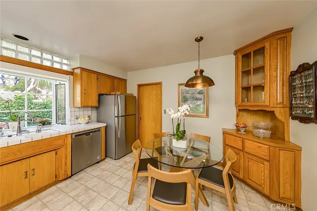 a dining room with stainless steel appliances granite countertop furniture a window and kitchen view