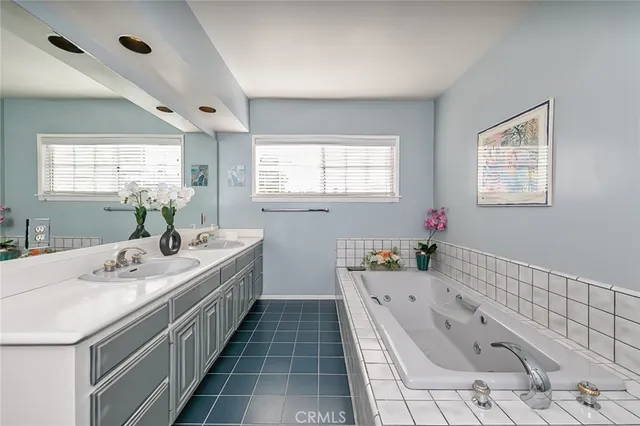 a bathroom with a granite countertop tub a sink and a window