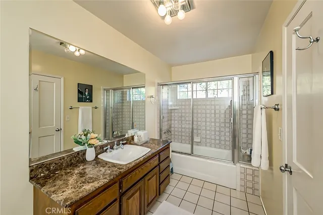 a bathroom with a granite countertop sink a mirror and a shower