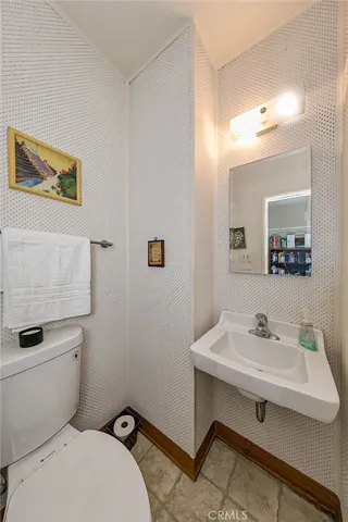a bathroom with a sink mirror and toilet