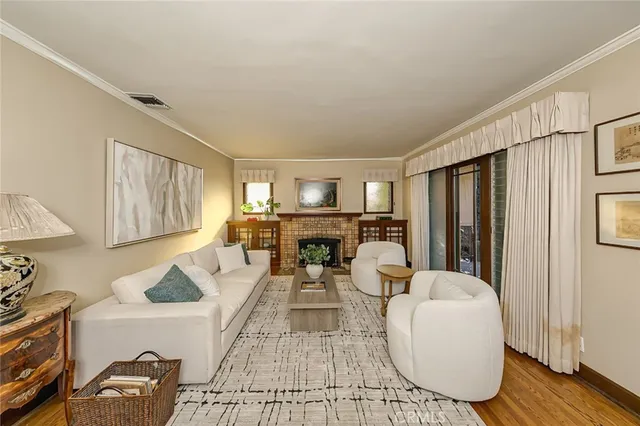 a living room with furniture a table and kitchen view
