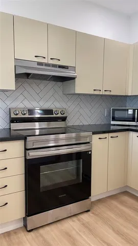 a stove top oven sitting inside of a kitchen