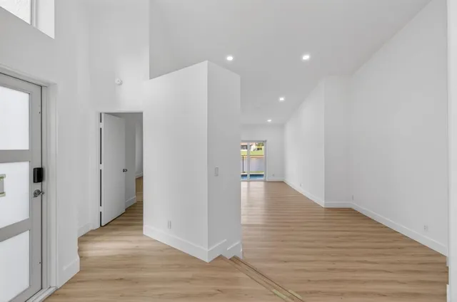a view of a hallway with wooden floor and staircase