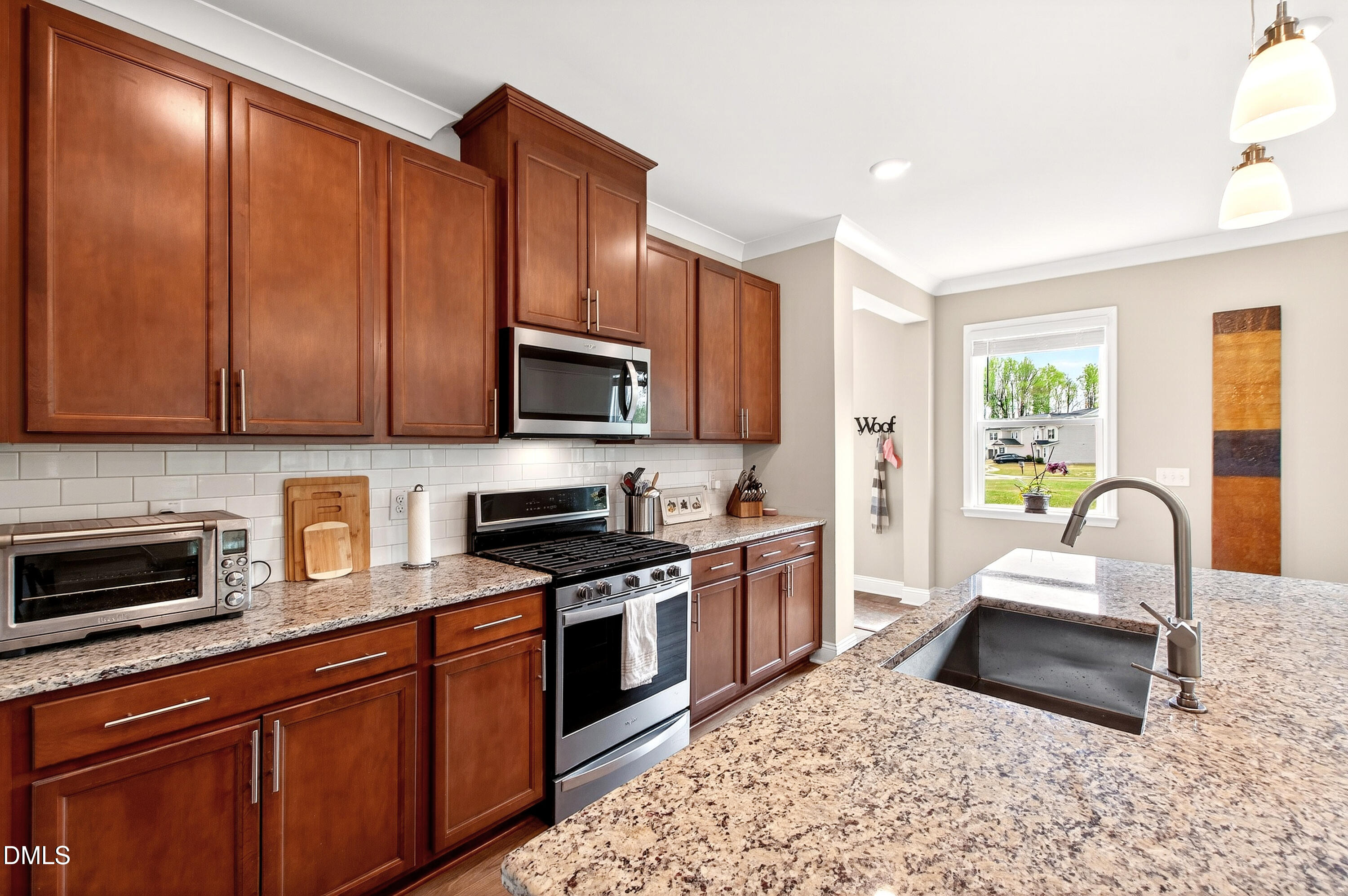 339 Summer Ranch Drive Fuquay-Varina, NC 27526 - Photo 15 of 42 a kitchen with stainless steel appliances granite countertop a stove top oven a sink dishwasher a dining table and chairs with wooden floor