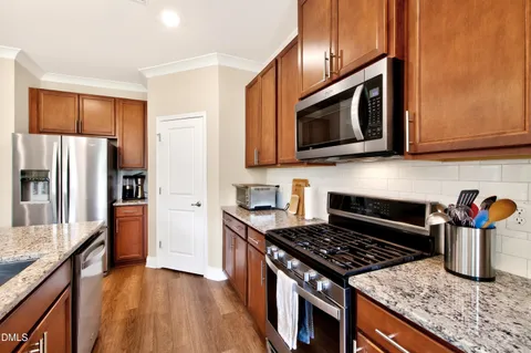 a kitchen with stainless steel appliances granite countertop a stove microwave refrigerator and sink