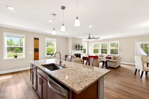 a living room with granite countertop kitchen island stainless steel appliances furniture stove and wooden floor