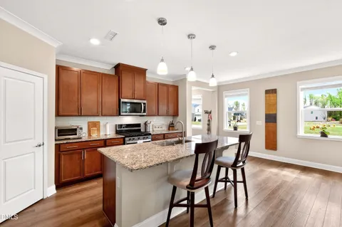 a kitchen with granite countertop kitchen island wooden cabinets and stainless steel appliances