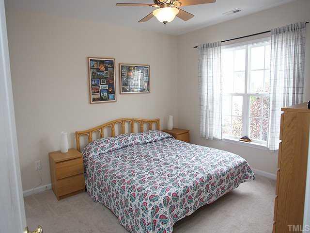7620 Silver View Lane Raleigh, NC 27613 - Photo 9 of 12 a bedroom with a large bed and a chandelier