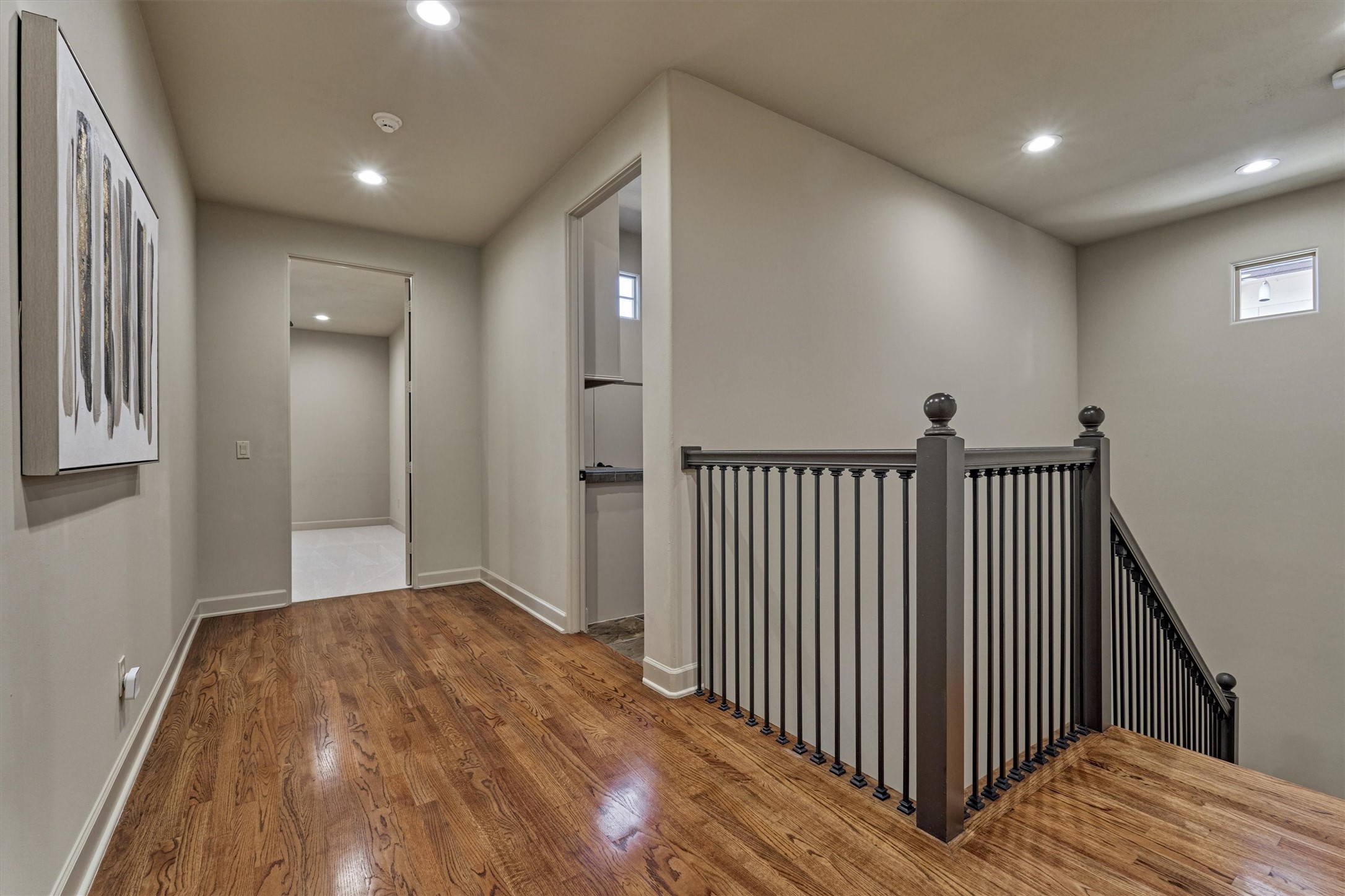 7 Dorset Square The Woodlands, TX 77381 - Photo 25 of 50 Second floor landing access to laundry on the right and bedroom at the end of the hall. Wood flooring and wrought iron spindles.