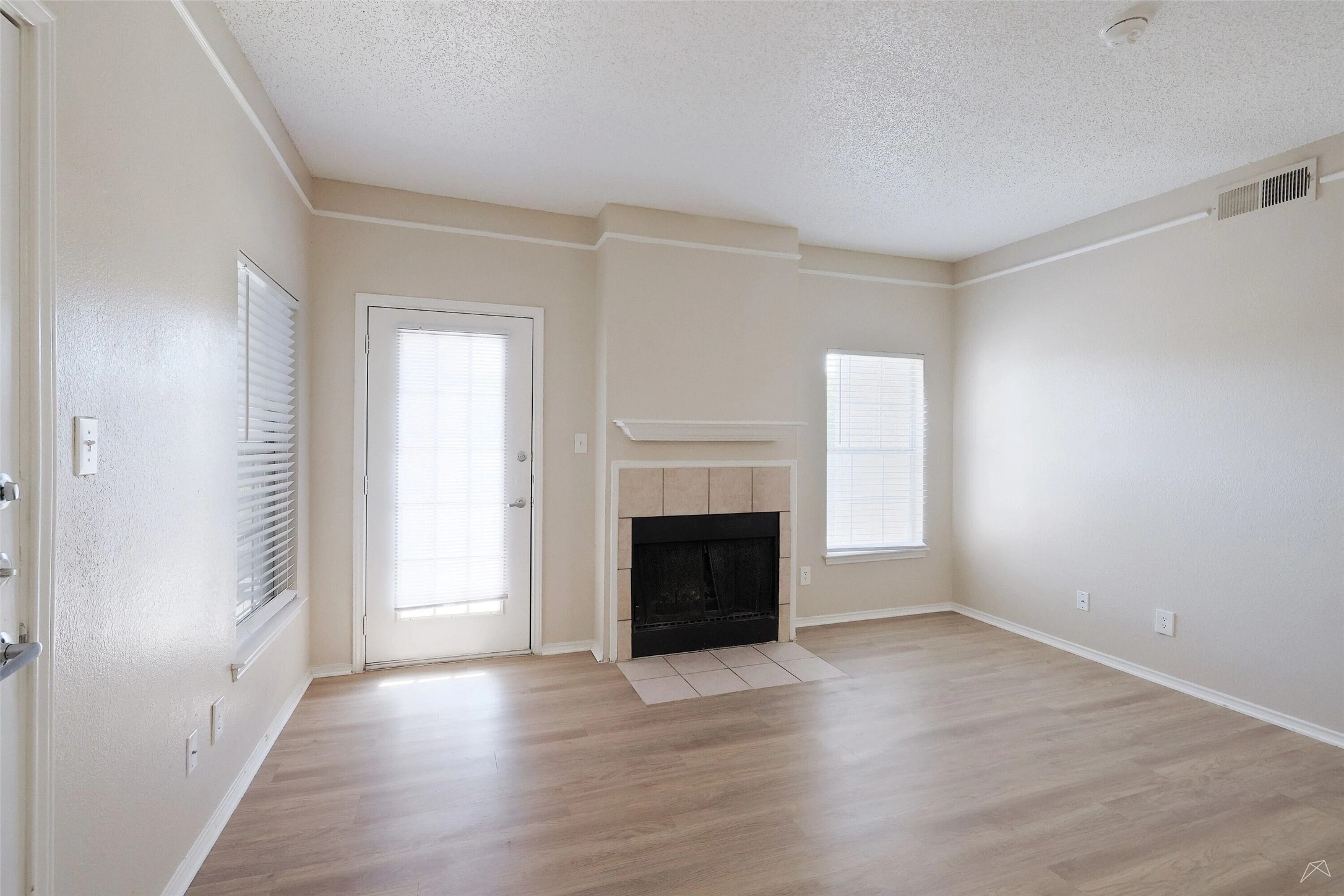 11908 Anderson Mill Road, Unit 321 Cedar Park, TX 78613 - Photo 11 of 24 an empty room with wooden floor fireplace and windows