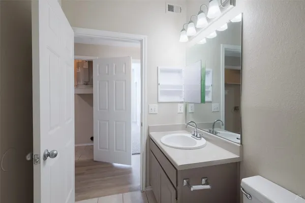 a bathroom with a sink a toilet and a mirror