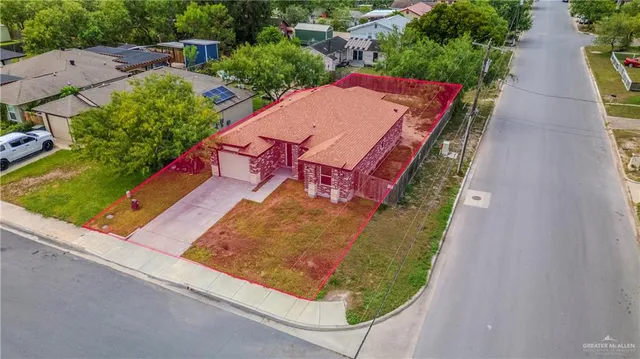 an aerial view of residential houses with outdoor space and street view