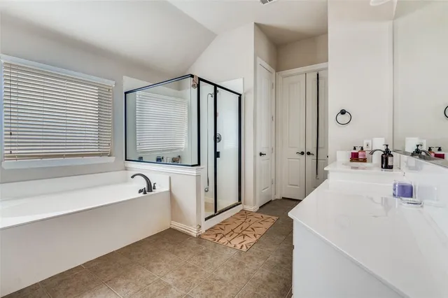 a spacious bathroom with a tub sink and mirror